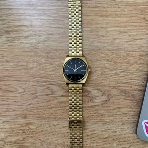Gold and black Nixon time teller
